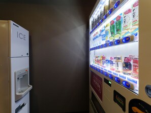 Un distributeur automatique proposant une variété de boissons et muni d’un compartiment séparé pour la distribution de glaçons.