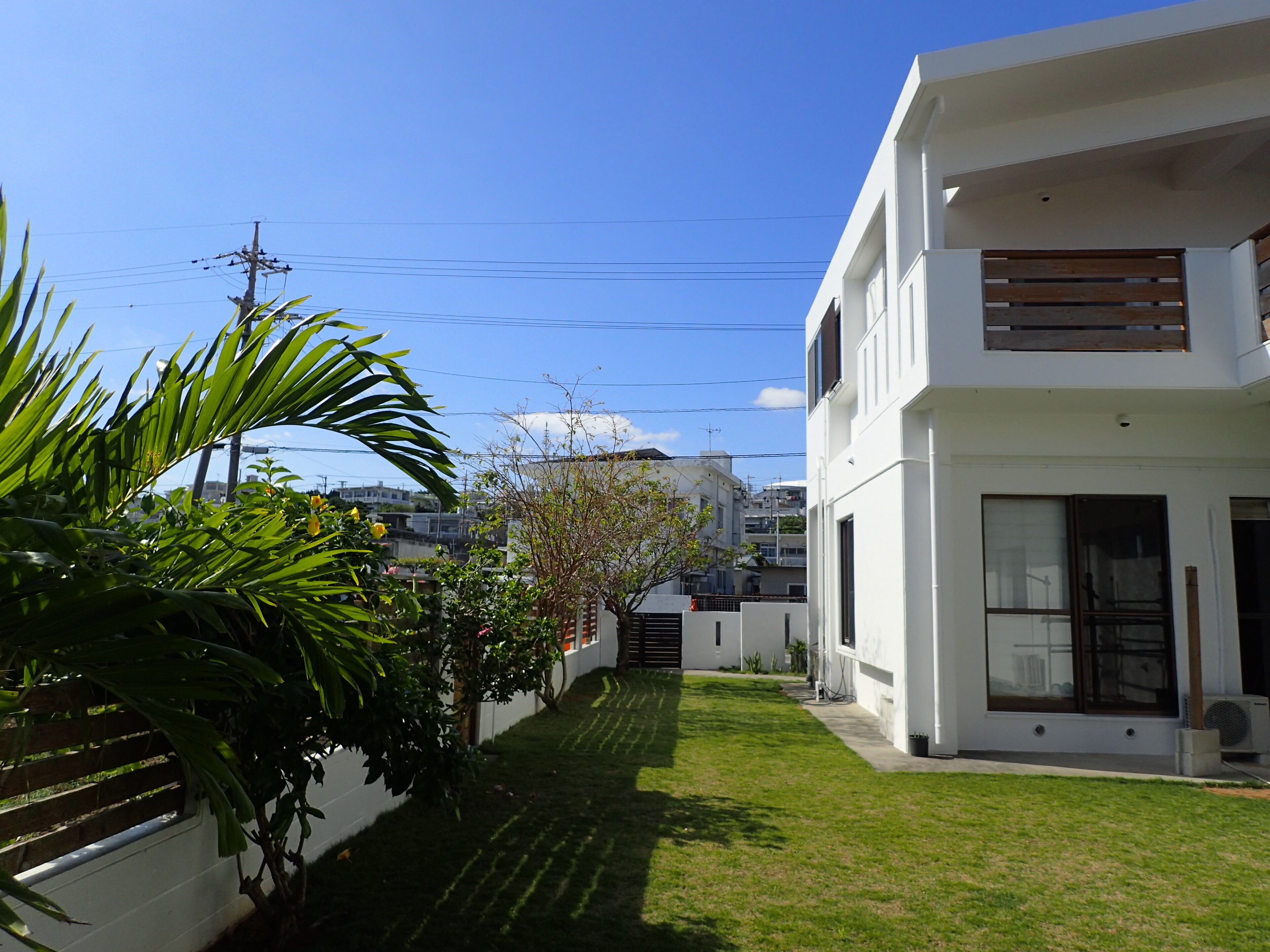 A modern two-story house with a well-maintained lawn and a white exterior.