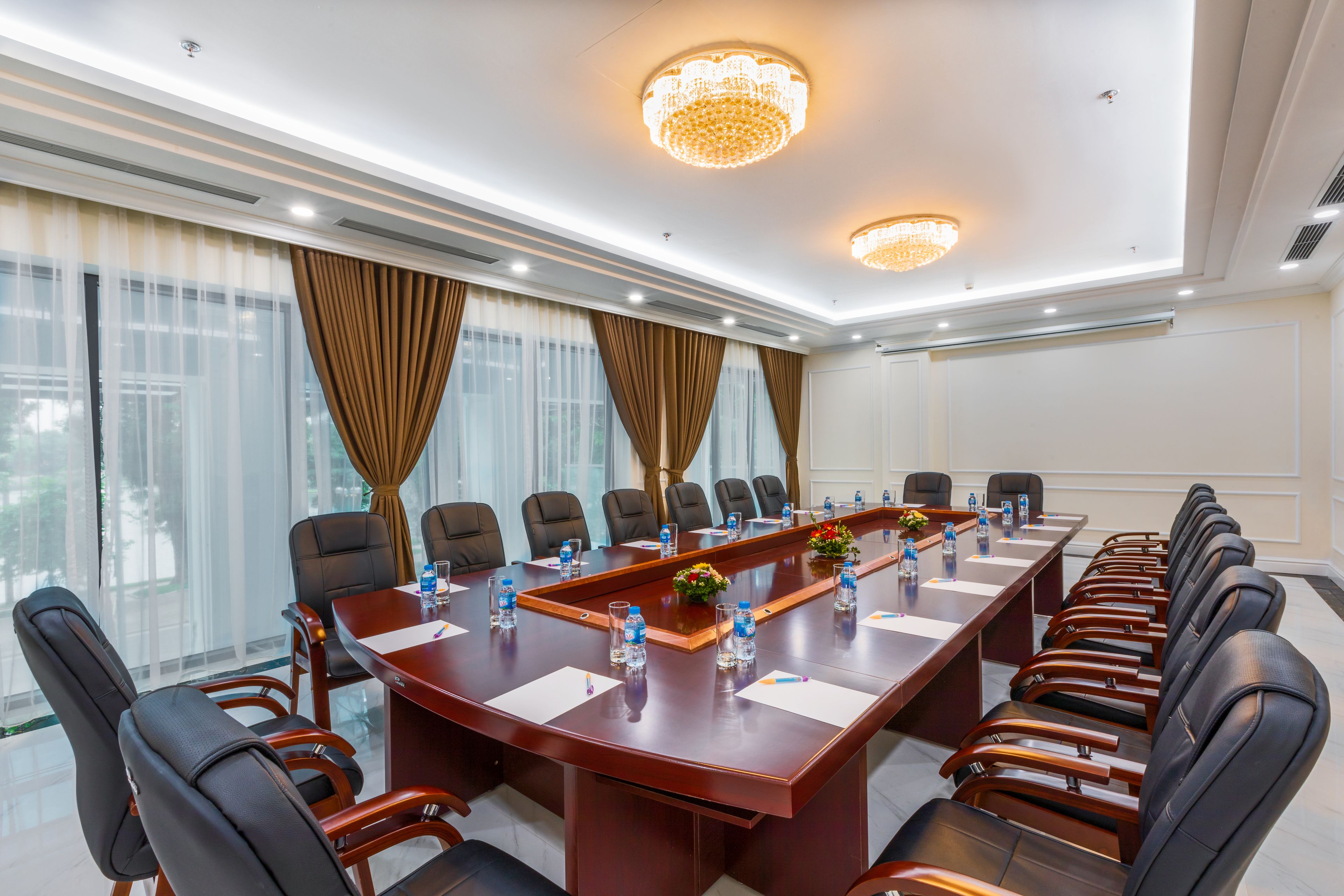 A conference room with a long table, chairs, and a chandelier.