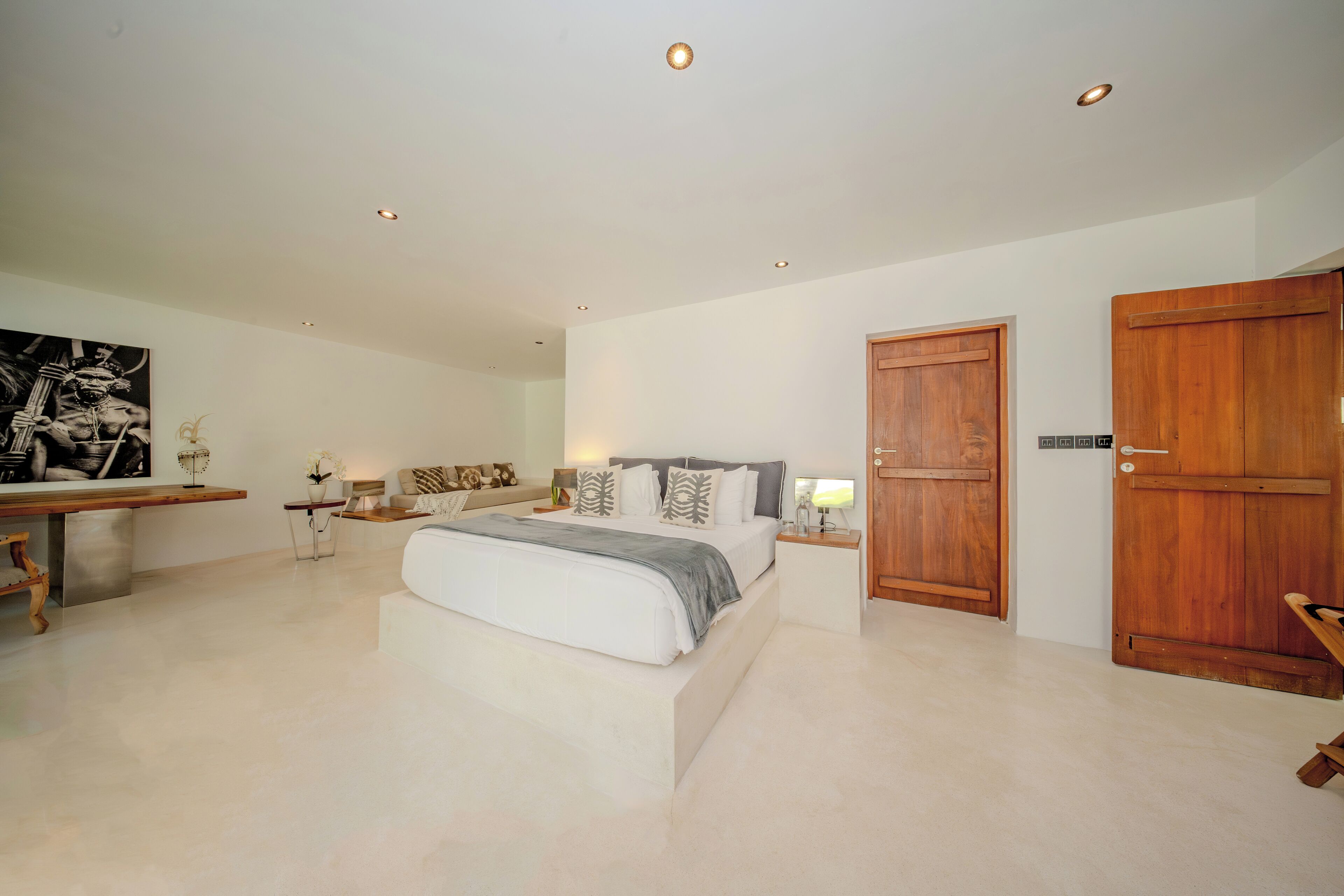 A bedroom with a bed, bedside tables, a wooden wardrobe, and a painting on the wall.