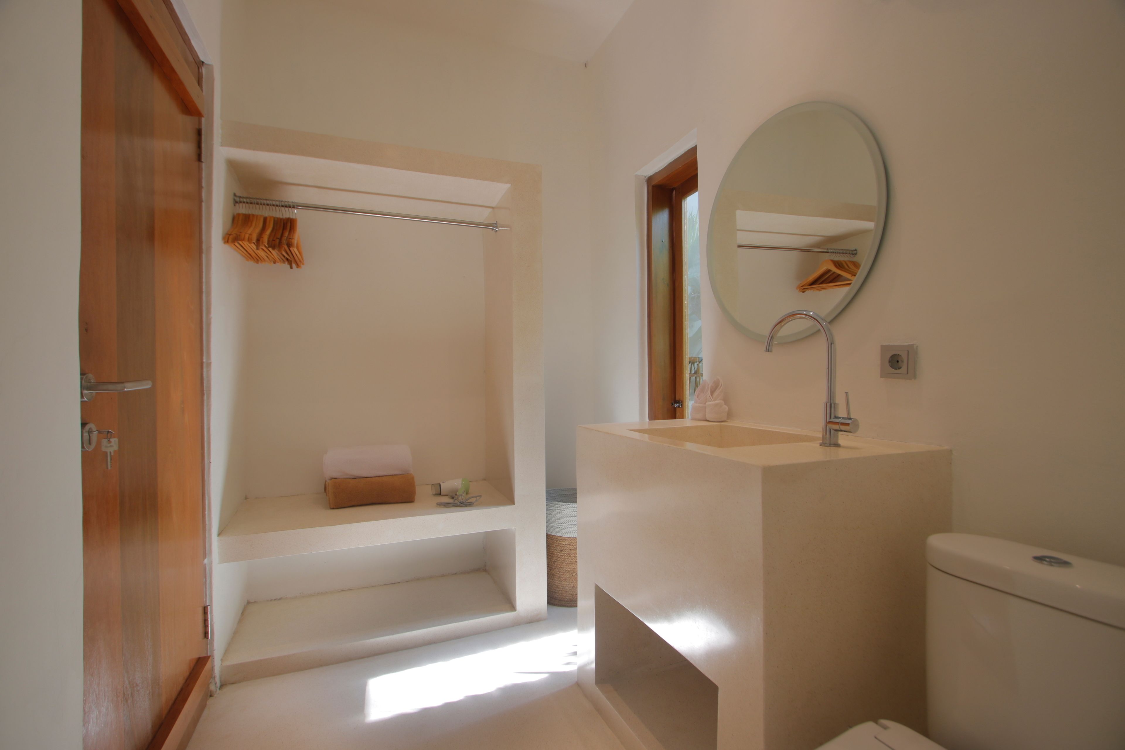 Een badkamer met een bad, een wastafel, een toilet en een spiegel.