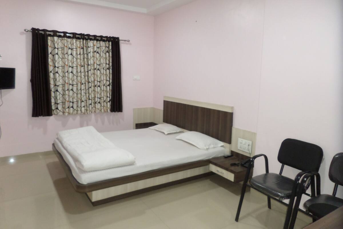 A neatly arranged bedroom with a bed, bedside tables, and a chair.