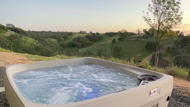 Ein Whirlpool mit Blick auf eine hügelige Landschaft.