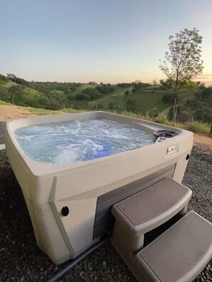 Ein Whirlpool mit Blick auf eine hügelige Landschaft.