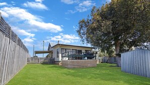Une maison de plain-pied dotée d’un patio couvert et d’une petite terrasse.