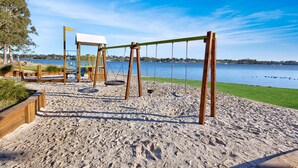 Une plage de sable avec des balançoires et une aire de jeux.
