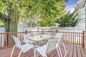 A covered patio with a table and chairs, surrounded by a white picket fence and a tree. - Spacious 4 Bed / 2.5 Bath Condo with Large Kitchen, Free Parking - Pet Friendly! (Boston)