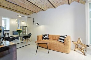 Ein modernes Wohnzimmer mit einer Couch, einem Couchtisch und einer sternenartigen Leuchte.