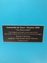 Una targa con informazioni sul dipinto de La Gioconda di Leonardo da Vinci, che ne ripercorre la storia e indica la sua collocazione attuale.