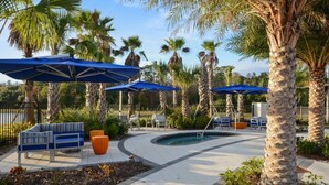 A poolside area with palm trees, blue umbrellas, and lounge chairs. - Aco238645 - Sonoma Resort - 7 Bed 6.5 Baths Villa (Kissimmee)