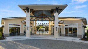 A modern building with a covered entrance, large windows, and a central decorative element. - Aco238645 - Sonoma Resort - 7 Bed 6.5 Baths Villa (Kissimmee)