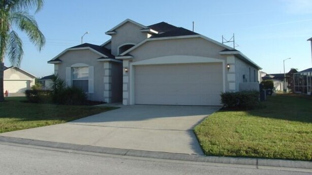 A single-story house with a garage, a front lawn, and a palm tree. - Ahr104 - Westbury - 4 Bed 3 Baths Villa (Davenport)