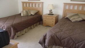 Two twin beds with brown bedding, a bedside table with a lamp, and a small wooden dresser. - Ahr104 - Westbury - 4 Bed 3 Baths Villa (Davenport)