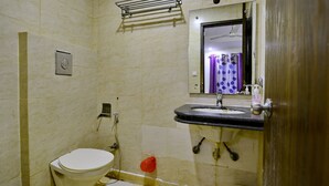 A bathroom with a toilet, sink, and shower. - D Inn (New Delhi)