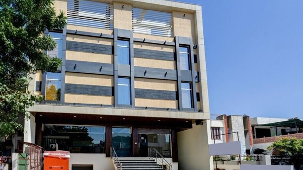 A modern building with a flat roof, large windows, and a staircase leading to the entrance. - D Inn (New Delhi)
