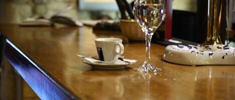 A bar area with a cup and a wine glass on the counter.