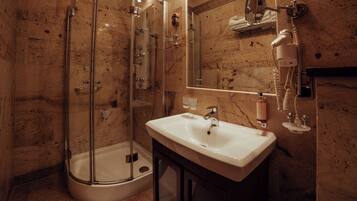 A bathroom with a glass-enclosed shower, a sink, and a mirror.