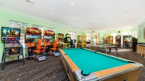 Ein Billardtisch in einem Raum mit Spielautomaten und einer Billardkugel.