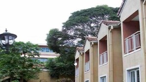 A hotel with a pool area, outdoor seating, and a lamp post. - Hotel  Victoria (Blantyre)