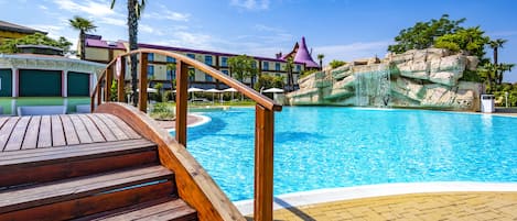 Una piscina al aire libre de temporada, sombrillas