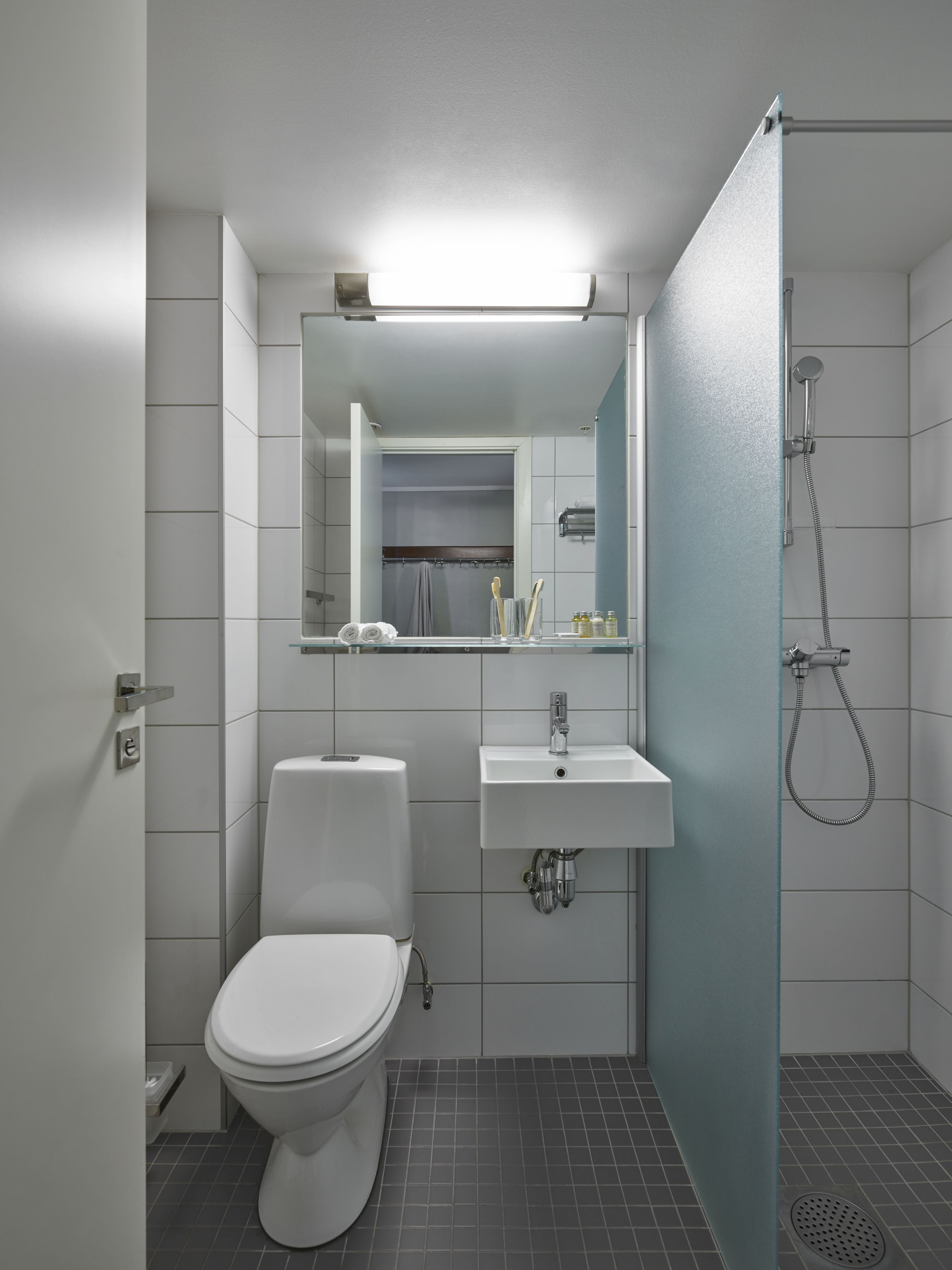 A modern bathroom with a toilet, sink, and shower.