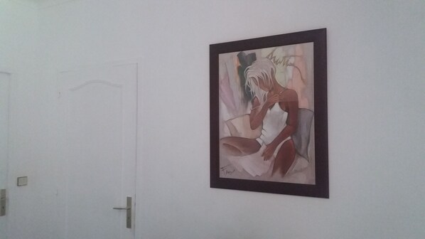A framed artwork on a wall next to a white door. - Au Pied des milles Étangs- LES CAPUCINS (Faucogney-et-la-Mer)