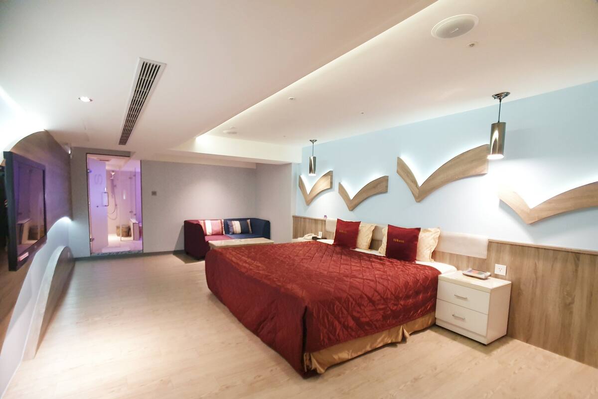 Une chambre à coucher moderne avec un grand lit, des tables de chevet et une coiffeuse.