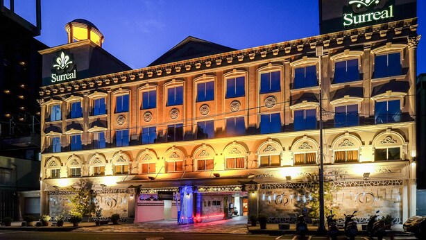A hotel with a classic facade, illuminated signage, and a prominent entrance with a blue-lit feature. - Surreal Motel- XinJhung Branch (New Taipei City)