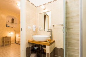 A modern bathroom with a large sink, mirror, and glass shower enclosure. - B&B Seros (Gaeta)