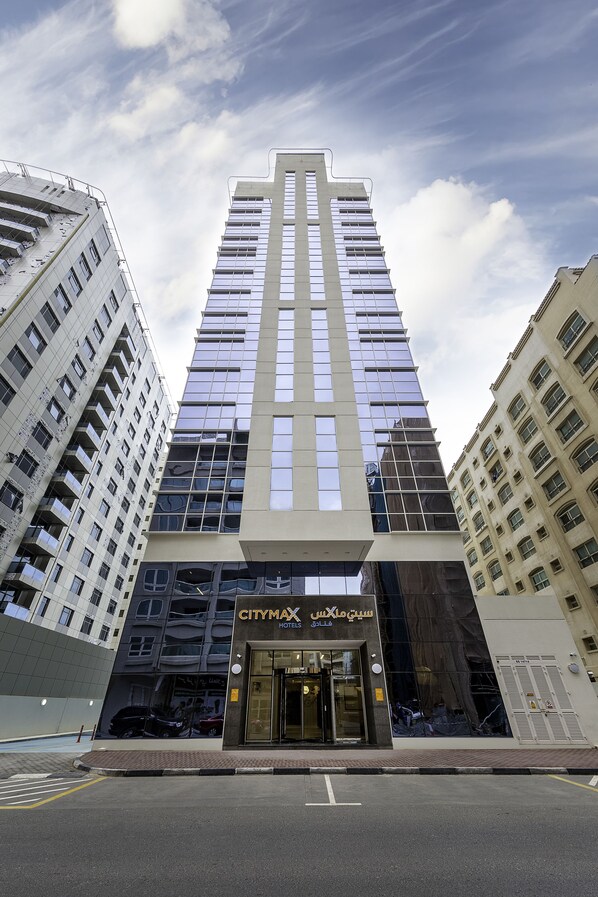 A tall hotel building with a modern facade, large windows, and a prominent entrance.