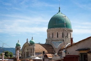 A historic building with a prominent green dome and smaller domes, surrounded by traditional architecture.