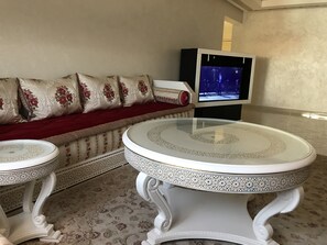 Apartamento Deluxe, 3 habitaciones, balcón | Zona de estar | Televisión de pantalla plana de 55 pulgadas con canales por satélite