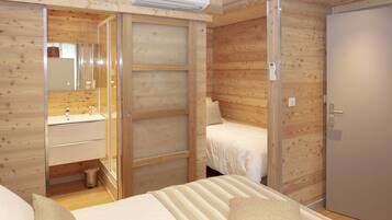Ein Zimmer mit Holzwänden, einem Bett, einem Nachttisch, einem Spiegel und einer Tür.