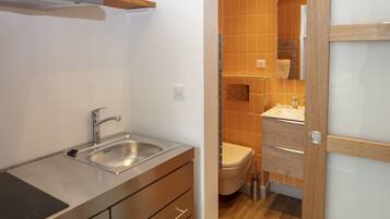 A modern kitchen with a stainless steel sink and wooden cabinets.