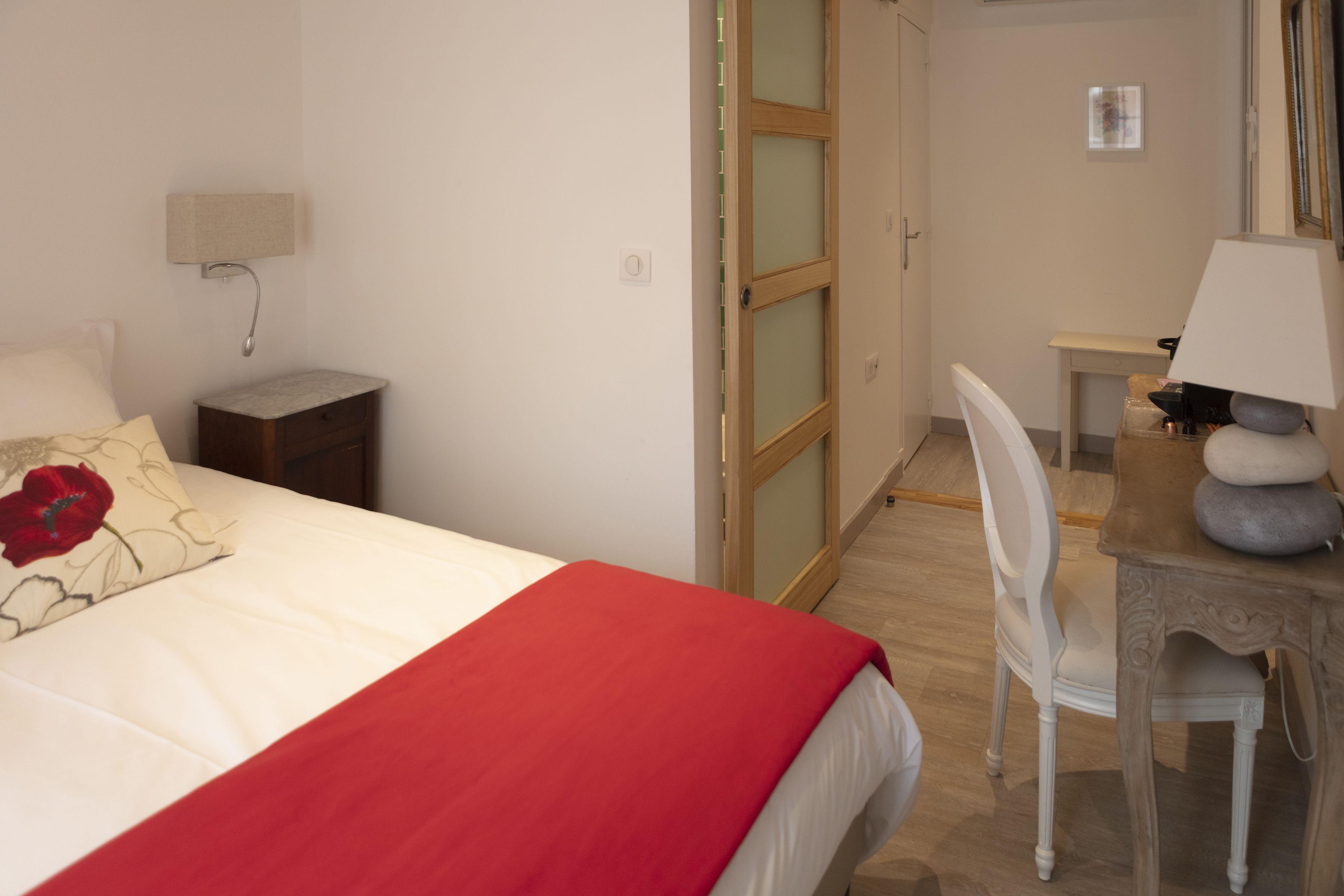 Ein Schlafzimmer mit einem Bett, einem Schreibtisch, einem Stuhl und einer Lampe.