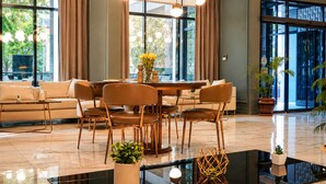 Ein modernes Wohnzimmer mit einem Glastisch, Ledersofas und einem Essbereich mit Stühlen.
