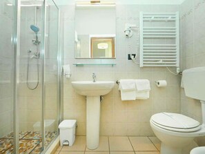 A modern bathroom with a glass-enclosed shower, a pedestal sink, a toilet, and a towel rack. - Hotel Venezia (La Spezia)