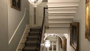 Eine Treppe mit Geländer, Teppichstufen und einer Deckenleuchte.
