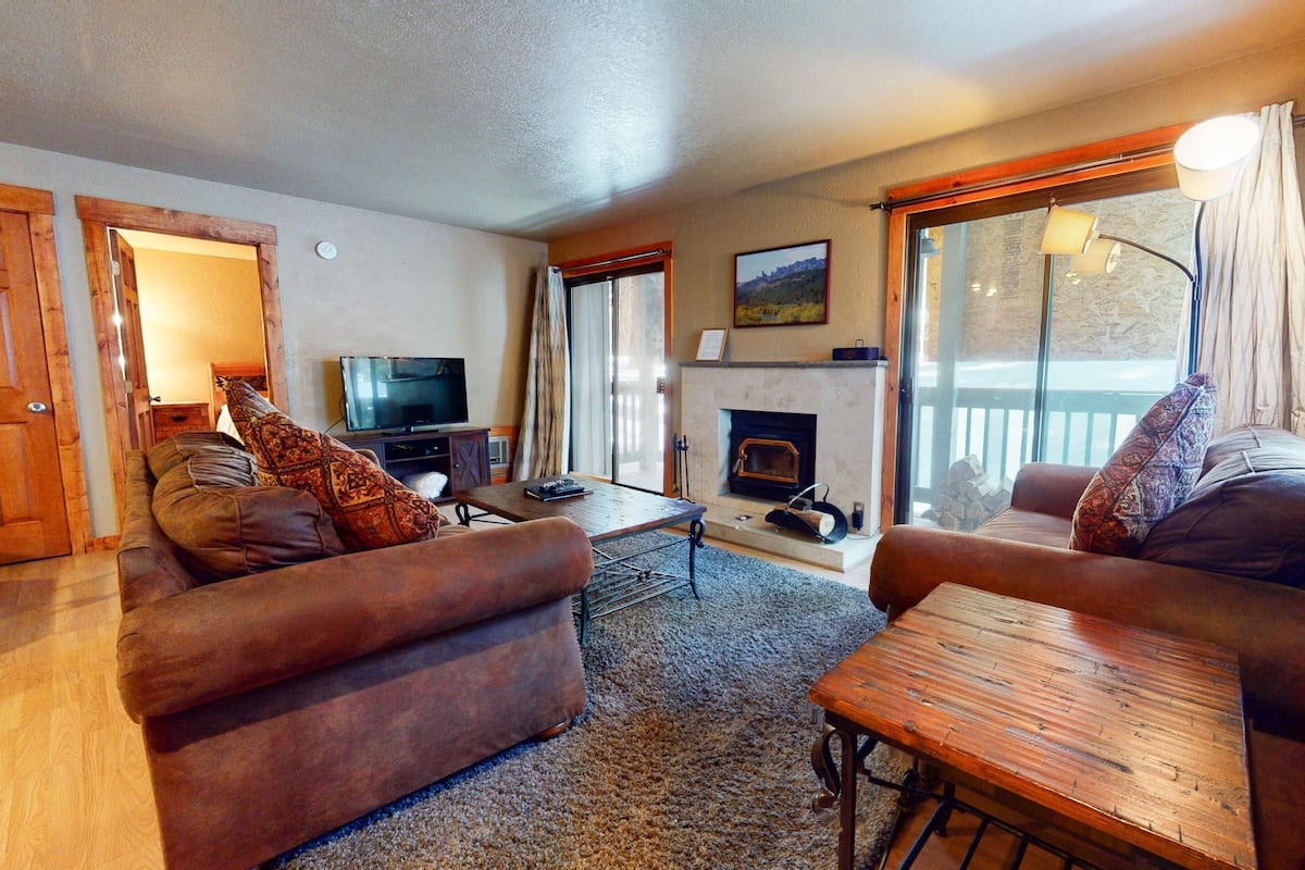 A cozy living room with a fireplace, a television, and comfortable seating.