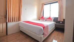 Un dormitorio con cama, cortinas, ventana y suelo de madera.