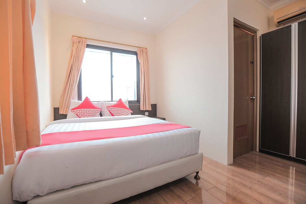 Un dormitorio con cama, cortinas, ventana y armario.