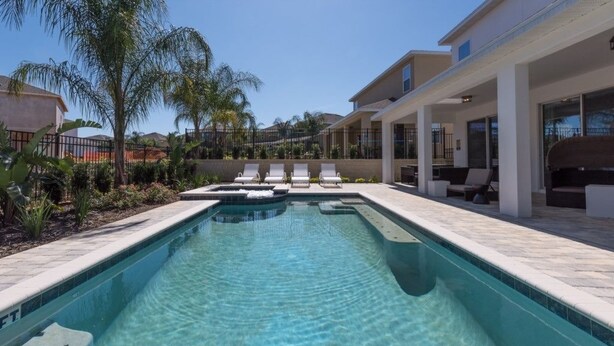 A swimming pool with lounge chairs and a covered patio area. - Je59003 - The Encore Club Resort - 9 Bed 8.5 Baths Villa (Kissimmee)
