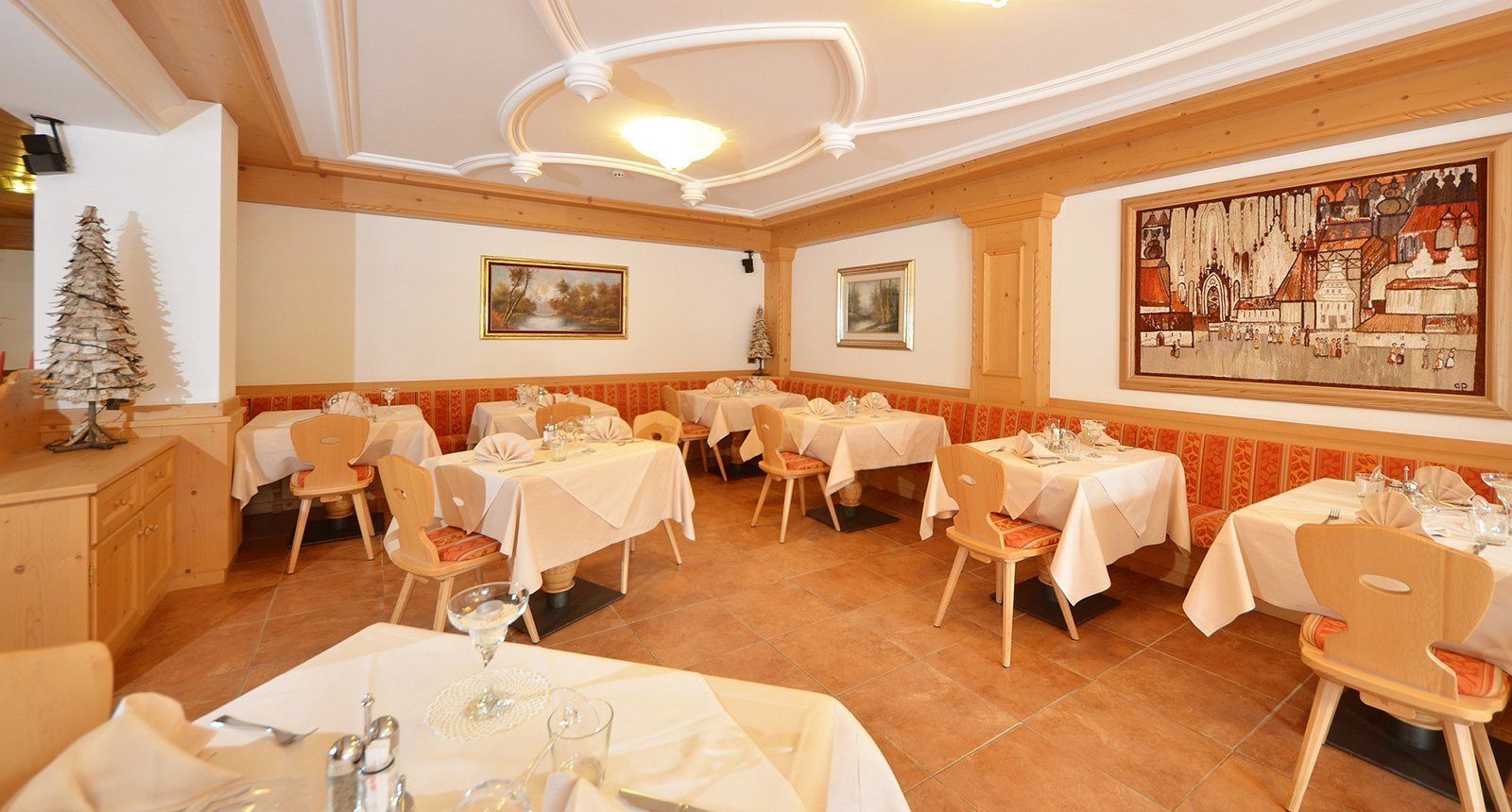 Un restaurant doté de nombreuses tables, aménagé pour accueillir les clients, et présentant un intérieur de style européen traditionnel, avec des poutres en bois et un décor classique.