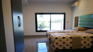Una habitación de hotel con dos camas, un ventanal grande y un diseño moderno.