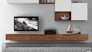 Una sala moderna con un televisor de pantalla plana, una estantería y un mueble de madera debajo.