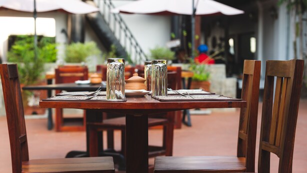 A dining table with chairs, a vase, and a plate.