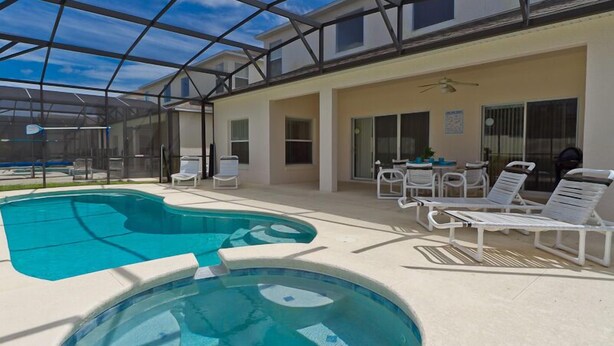 A covered outdoor swimming pool with lounge chairs and a ceiling fan. - Ahr205 - Highgate at Legacy Park - 5 Bed 4 Baths Villa (Davenport)