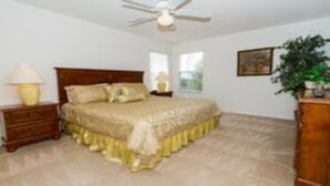 A bedroom with a bed, nightstands, a ceiling fan, a window, and a plant. - Ahr205 - Highgate at Legacy Park - 5 Bed 4 Baths Villa (Davenport)