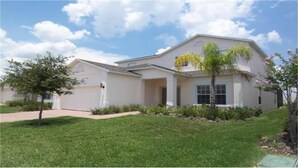 A two-story house with a front porch, a garage, and a well-maintained lawn. - Ahr205 - Highgate at Legacy Park - 5 Bed 4 Baths Villa (Davenport)