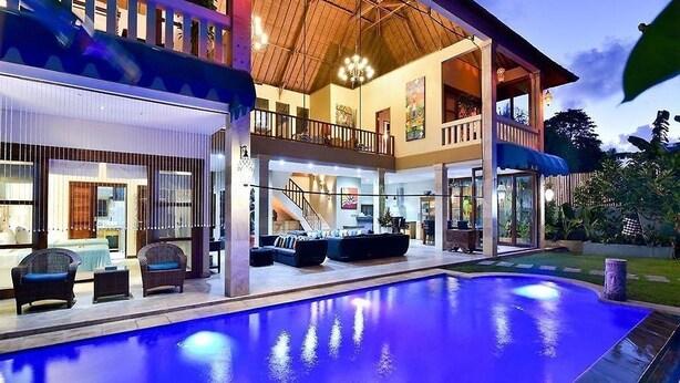 A two-story house with a swimming pool, outdoor seating, and a staircase leading to the upper level. - Bali Mystique Apartment (Keroboken Kelod)